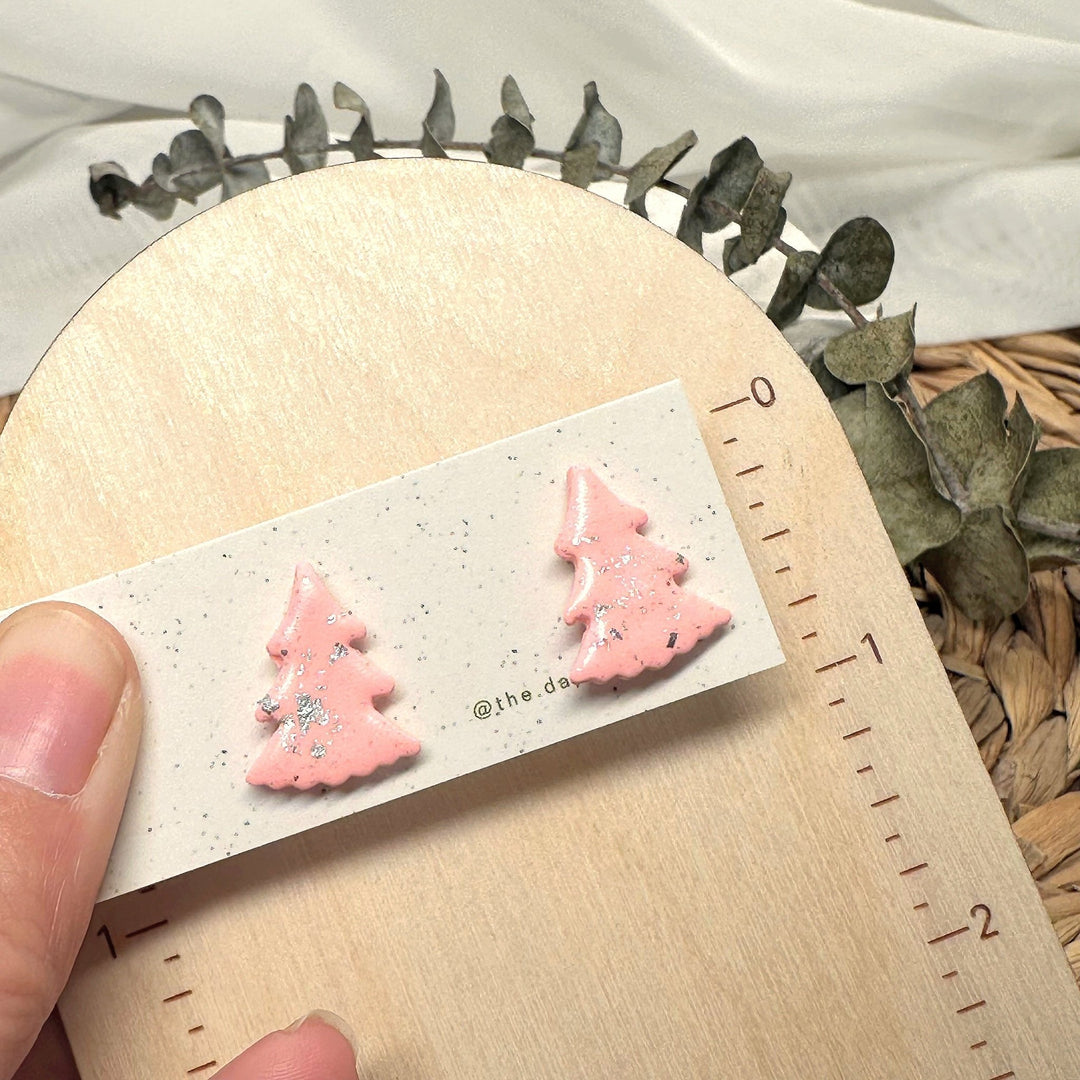 Juniper stud earrings beside a ruler showing size and scale