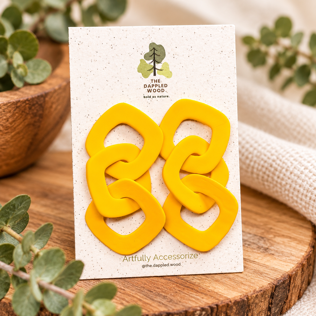 Lexa XL chain link statement earrings in bright yellow on a The Dappled Wood product card, showing three interlocking polymer clay links per earring.