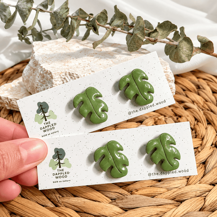 Marnie olive green Monstera leaf stud earrings on The Dappled Wood cards, enhanced product photograph.