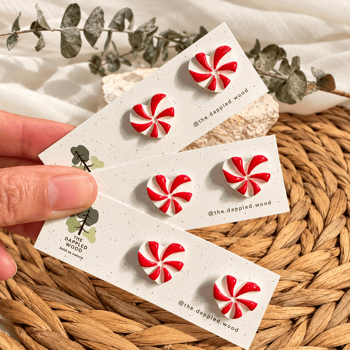 Darcie red and pearly white peppermint heart stud earrings on display cards.
