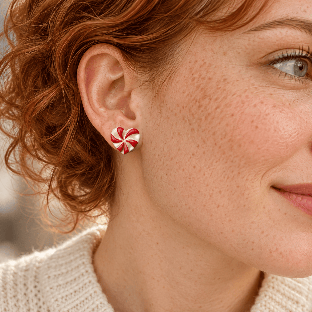 AI-generated styling preview of Darcie peppermint heart studs on a freckled model with copper curls; scale illustrative.