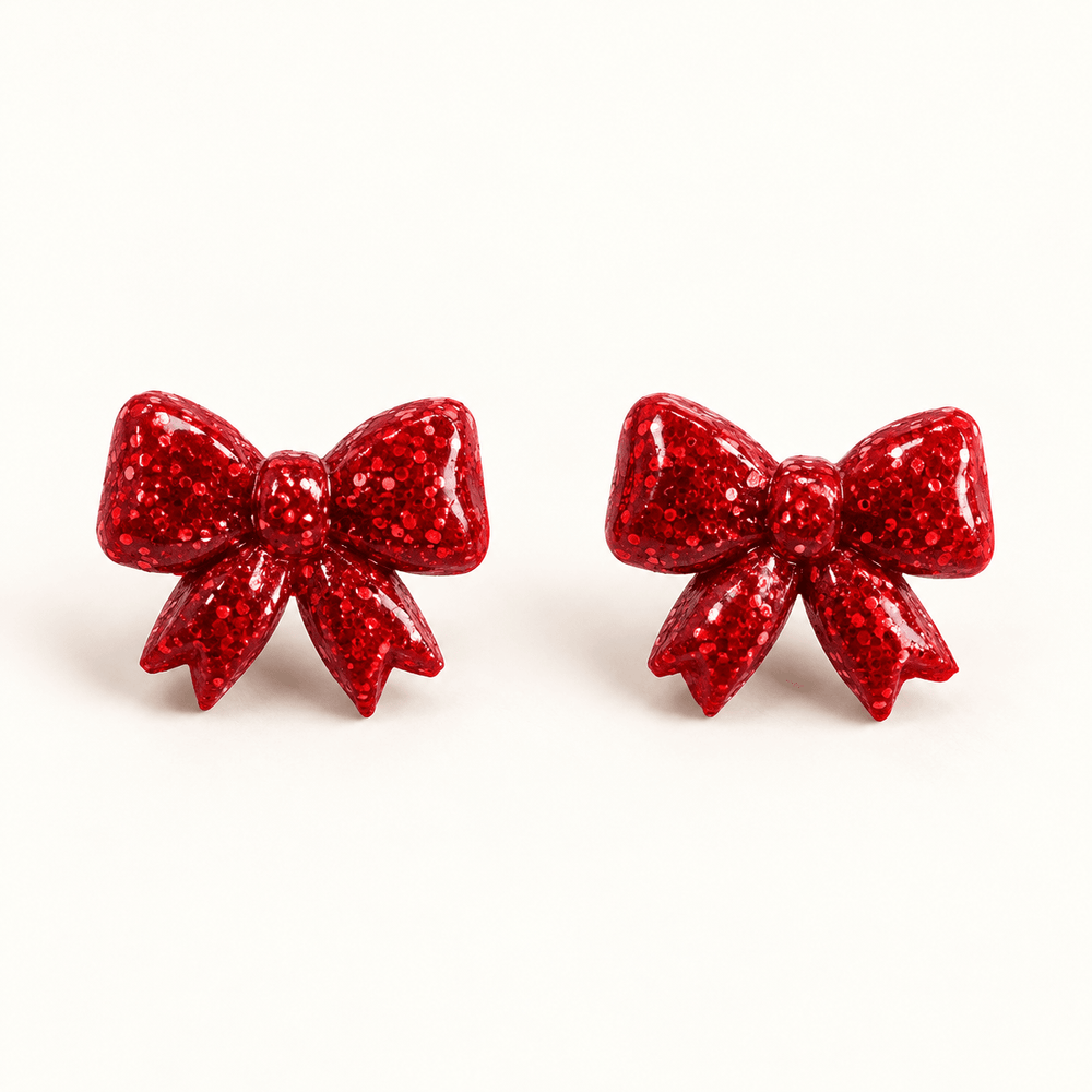 Nellie red glitter sculpted bow stud earrings on a white background.