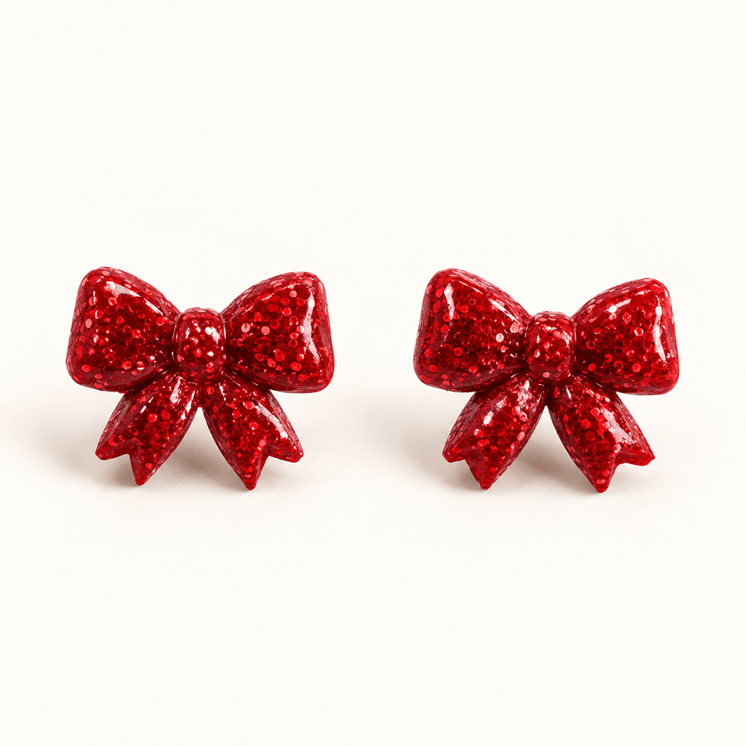 Nellie red glitter sculpted bow stud earrings on a white background.