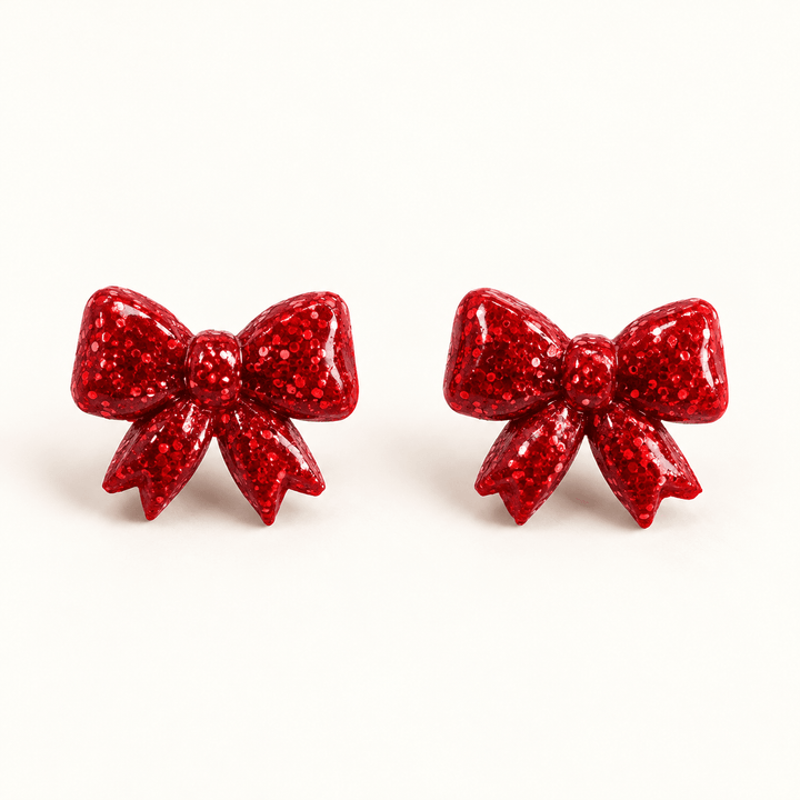 Nellie red glitter sculpted bow stud earrings on a white background.