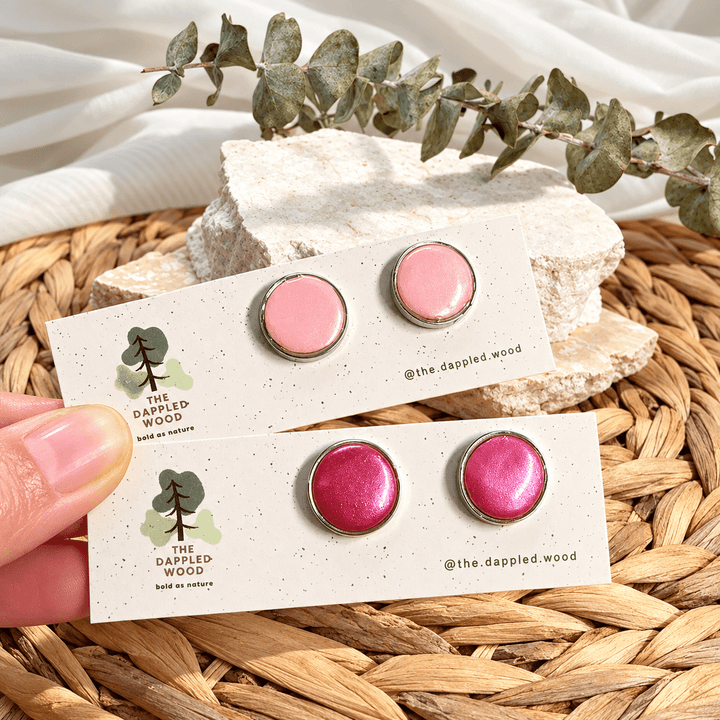Nerine pearl shimmer bezel studs in pastel pink and fuchsia with silver-tone rims on cards.