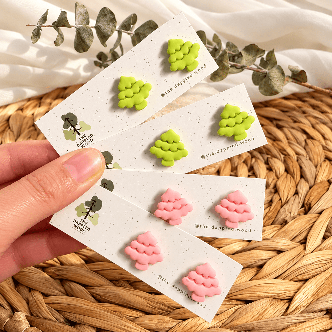Noella rounded Christmas tree stud earrings in lime green and pastel pink on cards.