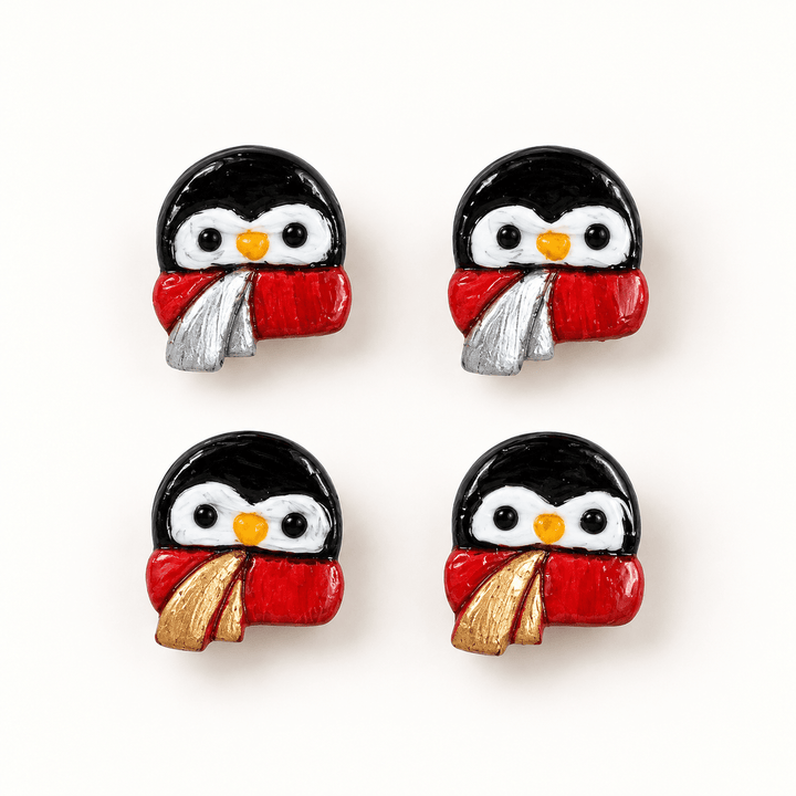 Pippa penguin stud earrings in gold and silver scarf-accent variants on a warm white background.