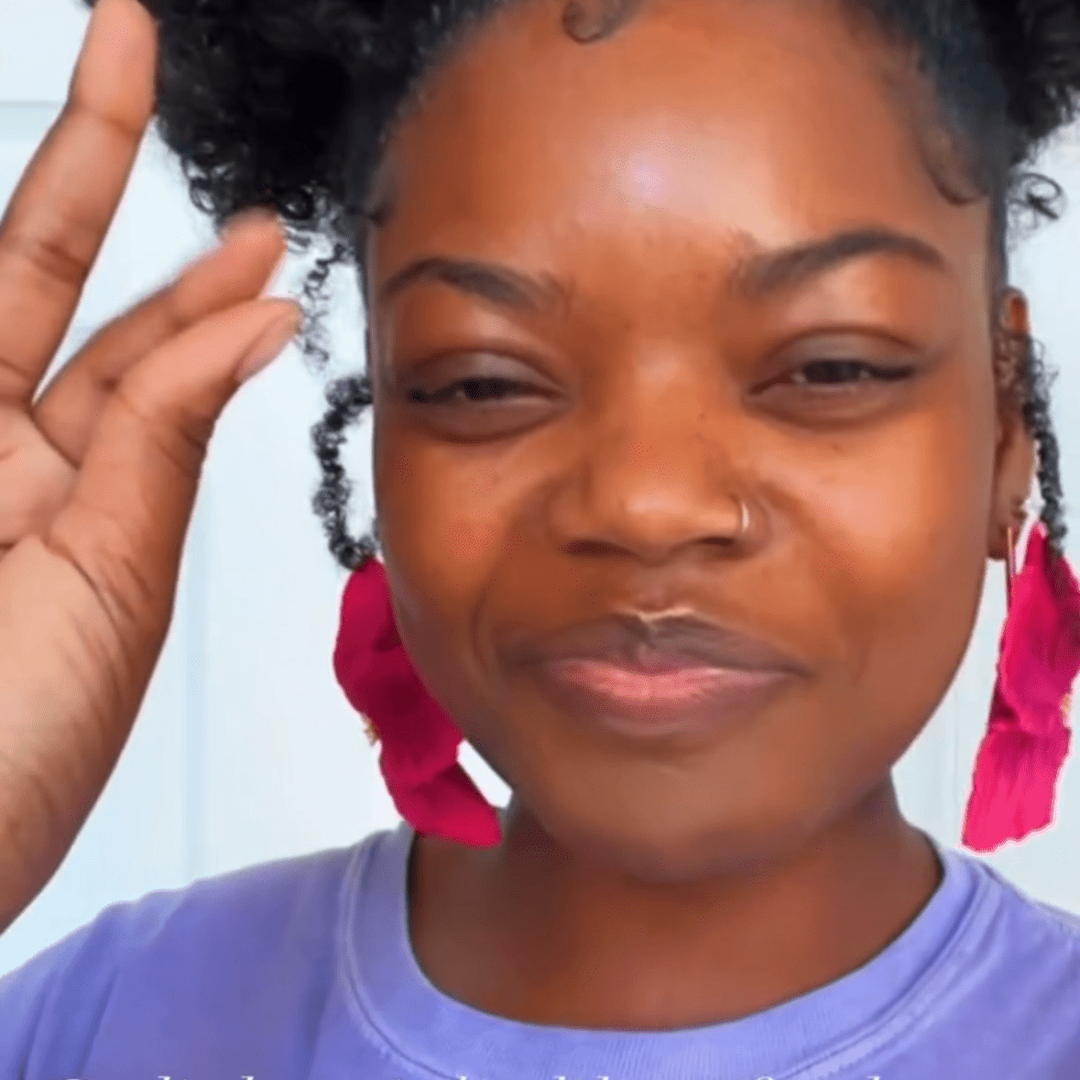 Customer wearing the Sabine earrings in Hibiscus by The Dappled Wood, showing bright pink petal inspired drops against a soft background.