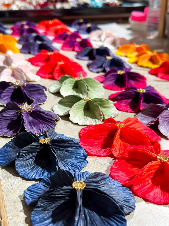 Assorted Sabine earrings by The Dappled Wood arranged in rows of vibrant colors, highlighting the handcrafted petal inspired statement design in bright natural light.