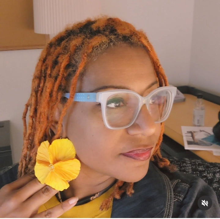 Customer wearing the Sabine earrings in Sunshine from The Dappled Wood featuring a bright yellow flower design.