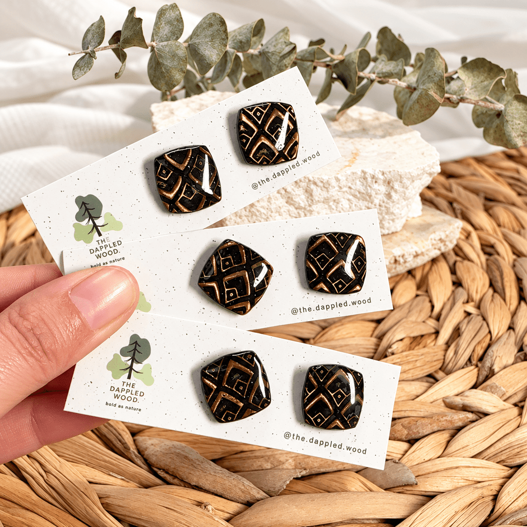 Safiya black and gold diamond pattern soft-square stud earrings on cards.