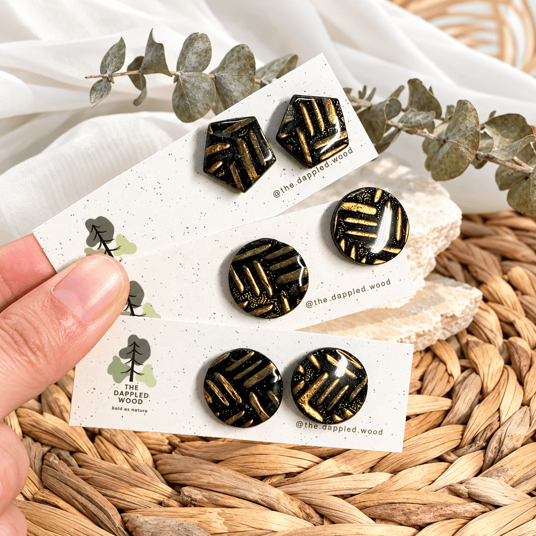 Safiya black and gold linear pattern stud earrings in angular and round shapes.