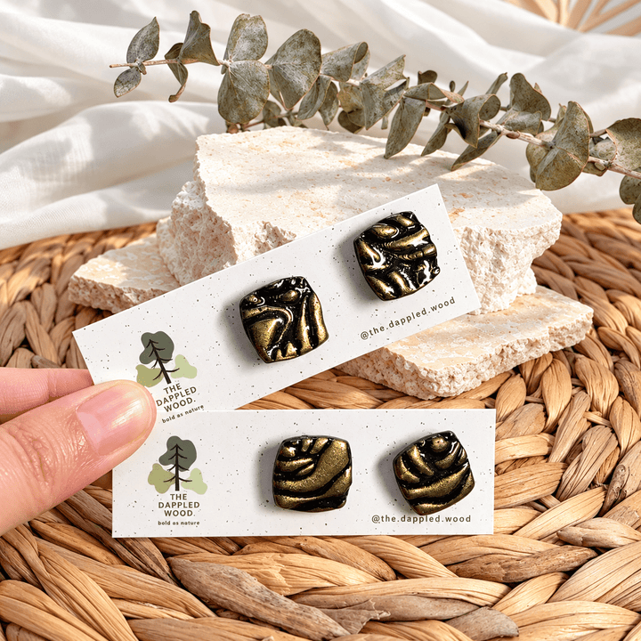 Safiya black and gold swirled soft-square stud earrings on cards.