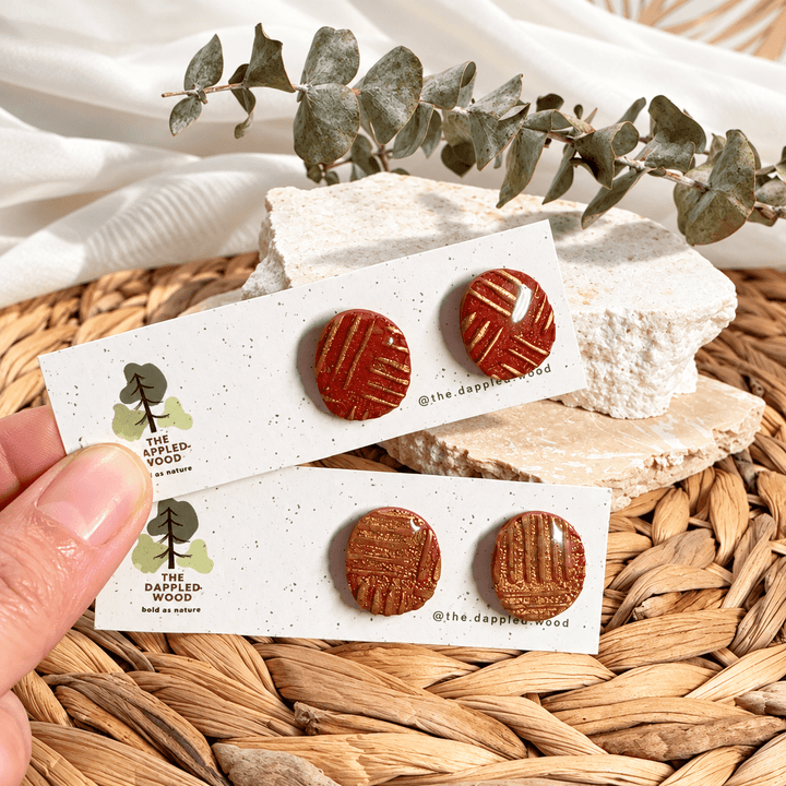 Safiya terracotta and gold fine linear pattern rounded stud earrings.