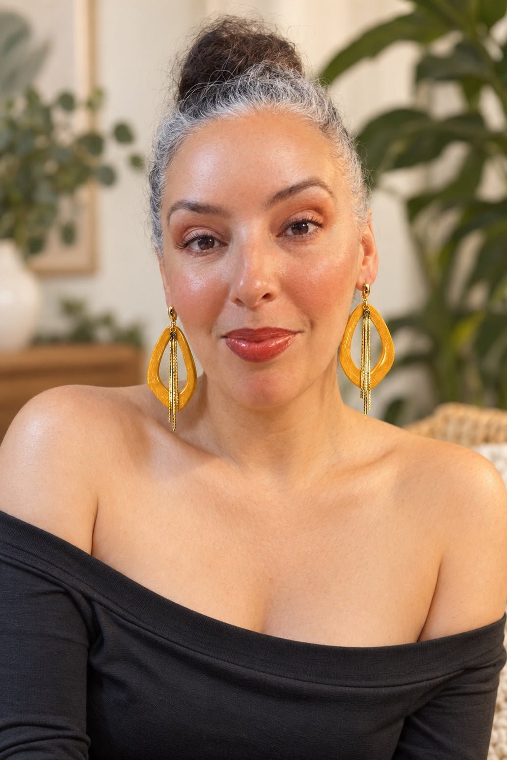 Woman wearing golden yellow Soraya shimmer earrings with five-strand gold tassels.