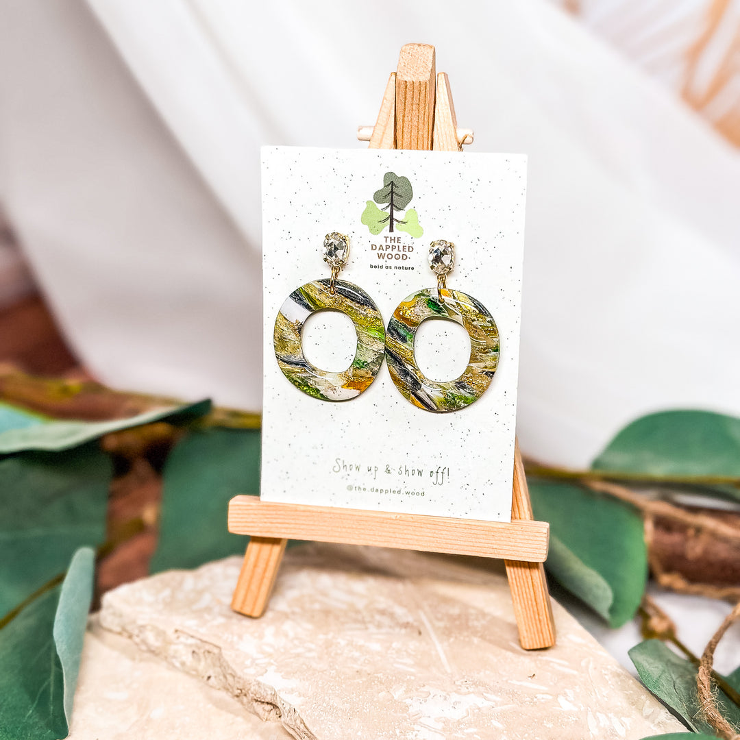 The Dappled Wood green faux stone swirl hoop earrings from the Spring 2024 collection, handmade with polymer clay for a lightweight design suitable for sensitive ears.