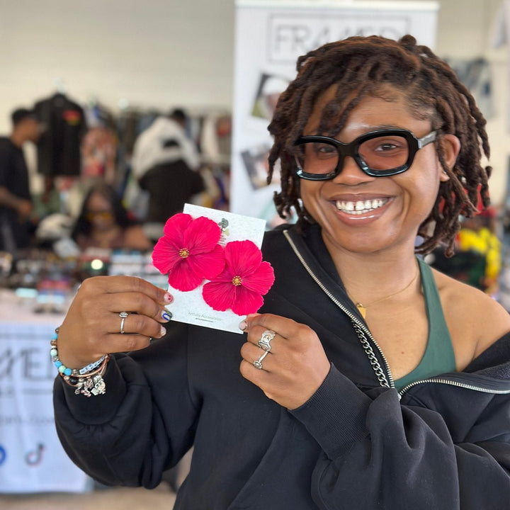 Happy customer showing off The Dappled Wood's bold hot pink Sabine floral earrings at a spring market. The perfect earrings for flower lovers of statement jewelry