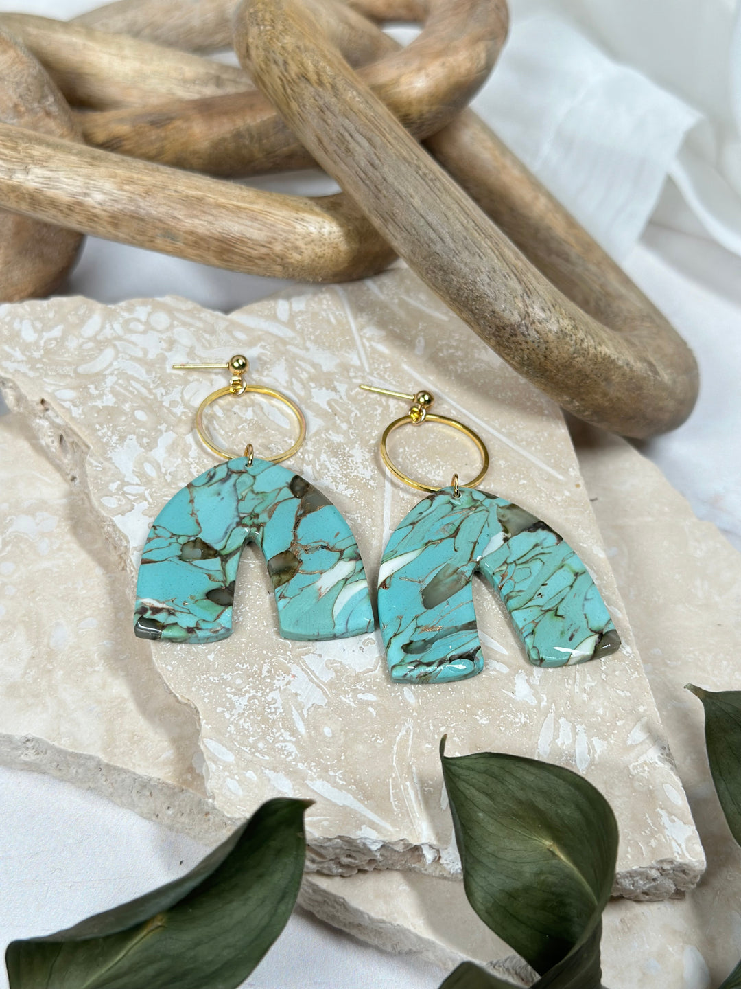 A variation of Dusty Turquoise earrings featuring a faux stone arch with hollow gold circle and ball posts. Handmade statement jewelry for summer 2024.