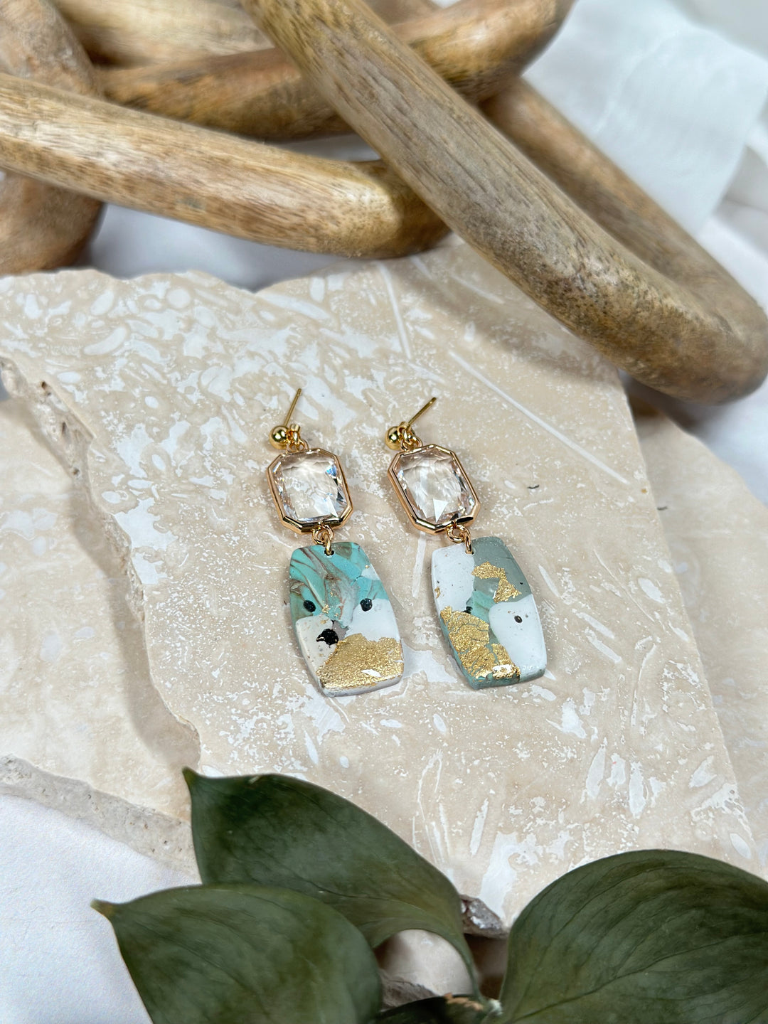 A variation of The Dappled Wood's Dusty Turquoise earrings with gold accents and rectangle glass gem. Handmade statement jewelry for summer 2024.