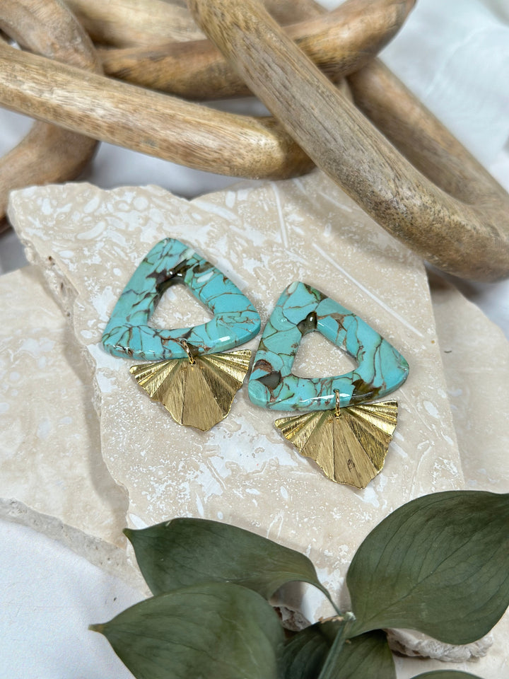 A variation of Dusty Turquoise earrings featuring triangular faux stone elements with gold fan charms. Handmade statement jewelry for summer 2024.