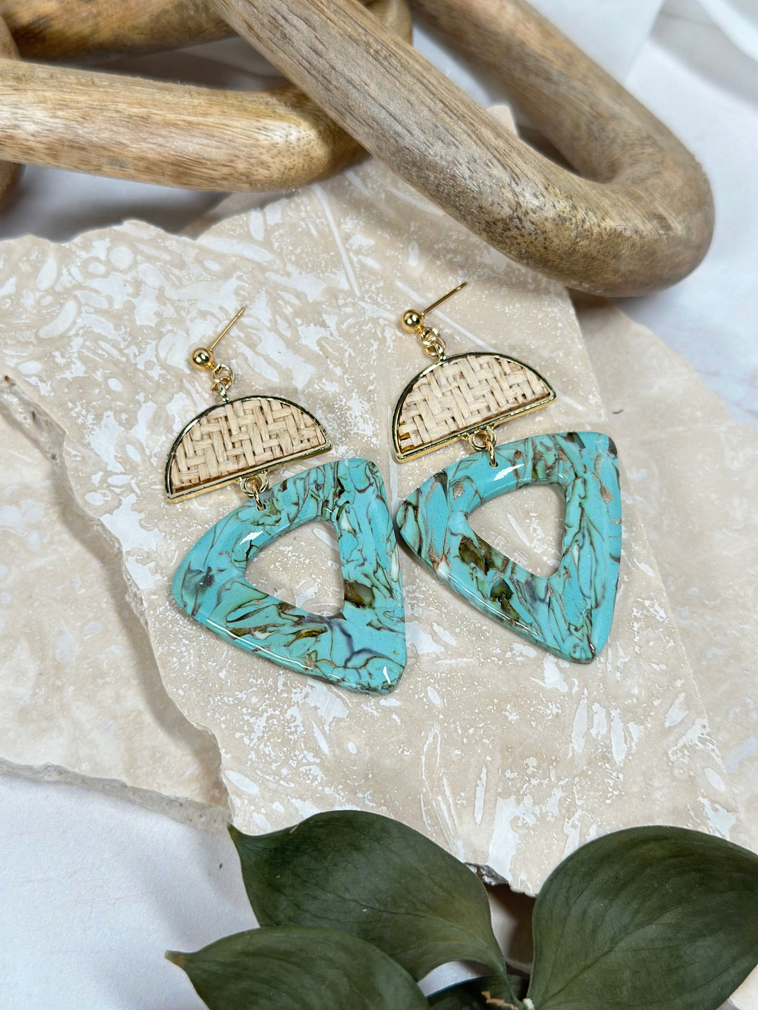 A variation of Dusty Turquoise earrings featuring a rattan semicircle charm and triangular faux stone. Handmade statement jewelry for summer 2024 from The Dappled Wood.