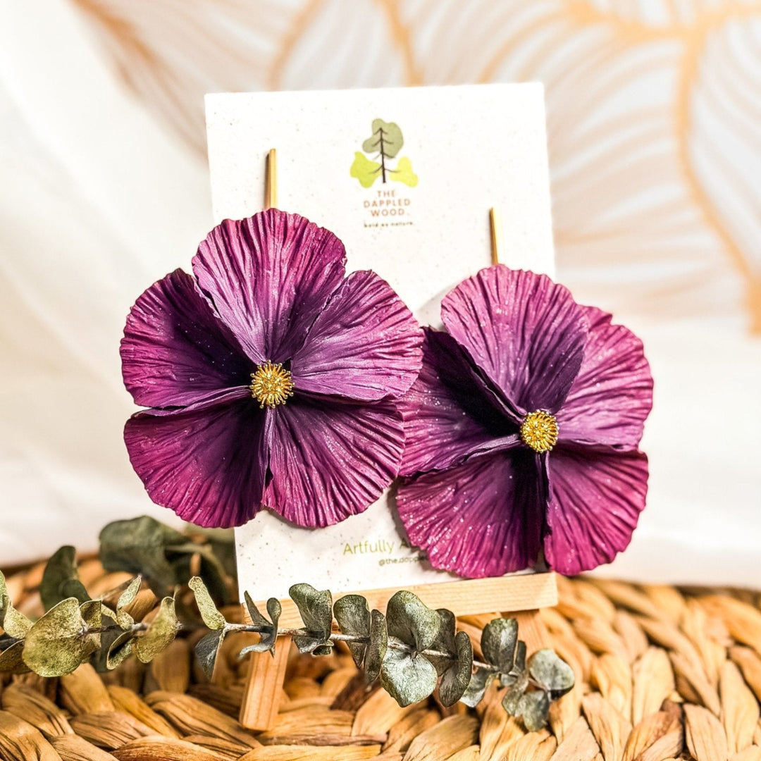 The Dappled Wood's Sabine polymer clay flower earrings in Plum feature a dark purple to magenta gradient. Bold floral clay earrings and lightweight statement jewelry, perfect for cocktail parties or gallery openings.