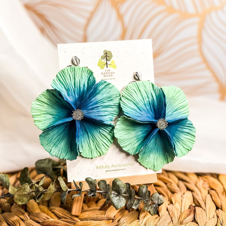 The Dappled Wood's Sabine polymer clay flower earrings in Seafoam feature a soft blue to green gradient. Bold floral clay earrings and lightweight statement jewelry, perfect for beach weddings or coastal vacations.
