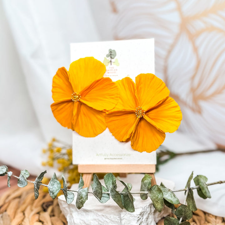 The Dappled Wood's Sabine polymer clay flower earrings in Tangerine feature an orange gradient. Bold floral clay earrings and lightweight statement jewelry, perfect for music festivals or bold summer looks.