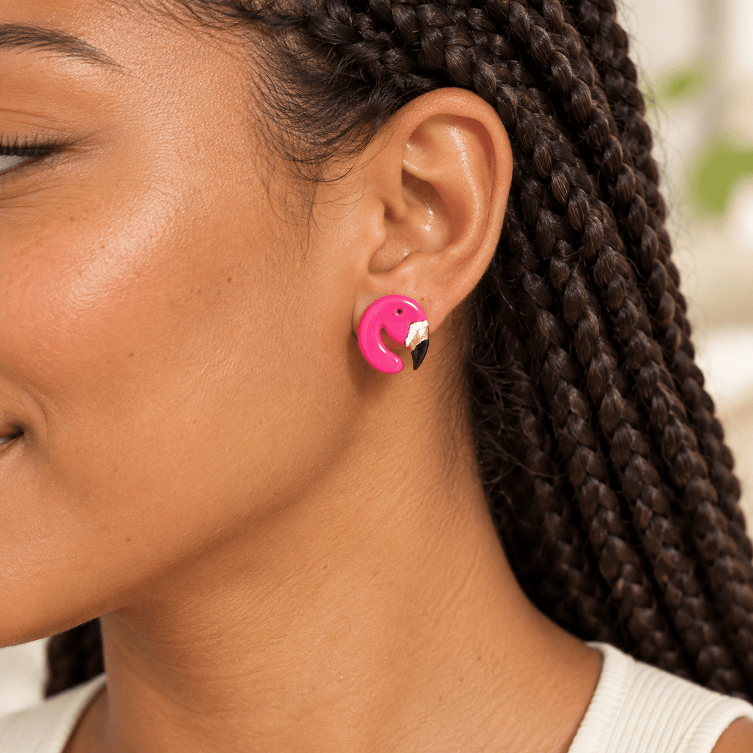 AI-generated styling preview of a model with dark box braids wearing a Tallulah flamingo stud; scale is illustrative