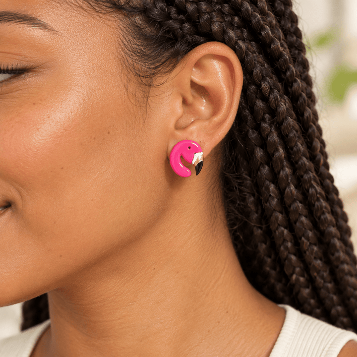 AI-generated styling preview of a model with dark box braids wearing a Tallulah flamingo stud; scale is illustrative