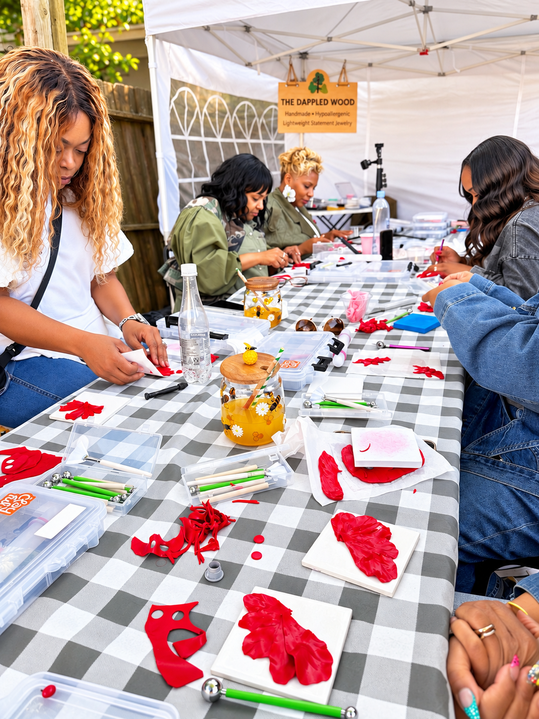 Guests making red floral jewelry together at an outdoor The Dappled Wood workshop