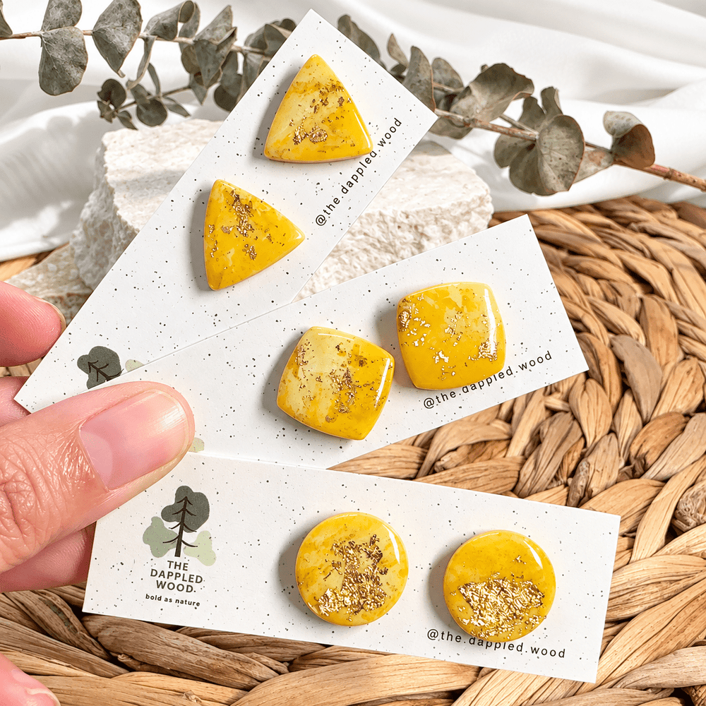Three pairs of Zinnia yellow marbled gold fleck stud earrings on display cards