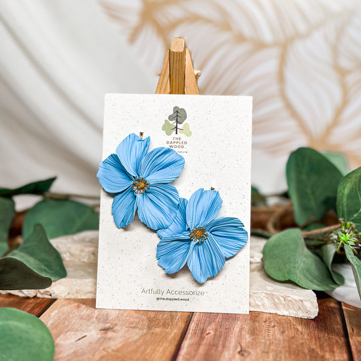 The Dappled Wood Frosted Petals handsculpted winter floral earrings in light blue featuring hypoallergenic gold bamboo posts from the New Year 2025 collection.