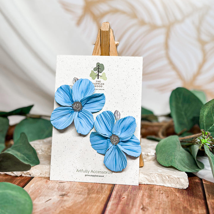 The Dappled Wood Frosted Petals handsculpted winter floral earrings in light blue featuring a hypoallergenic silver leaf post from the New Year 2025 collection.